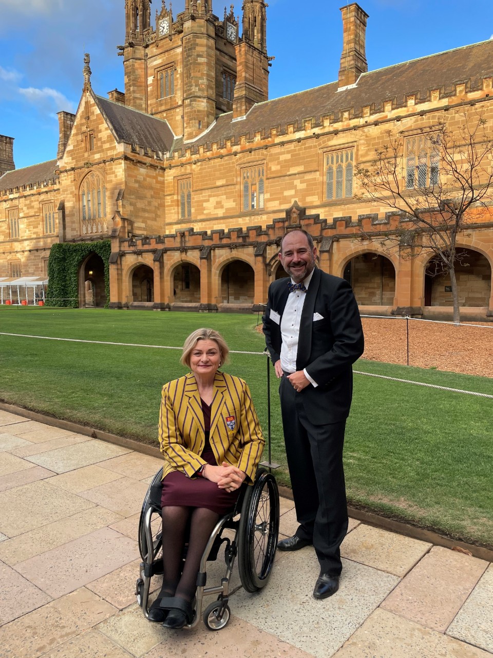 Jane Spring on the Quad grounds in a yellow and black striped blazer.