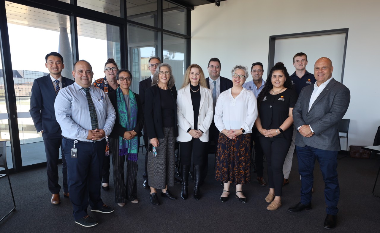Interior photograph of a large group of people in business attire.