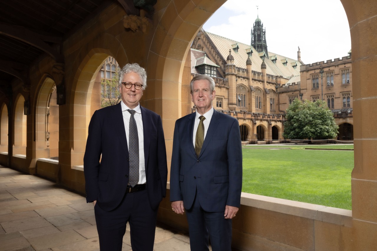 Two men standing under sandstone arches