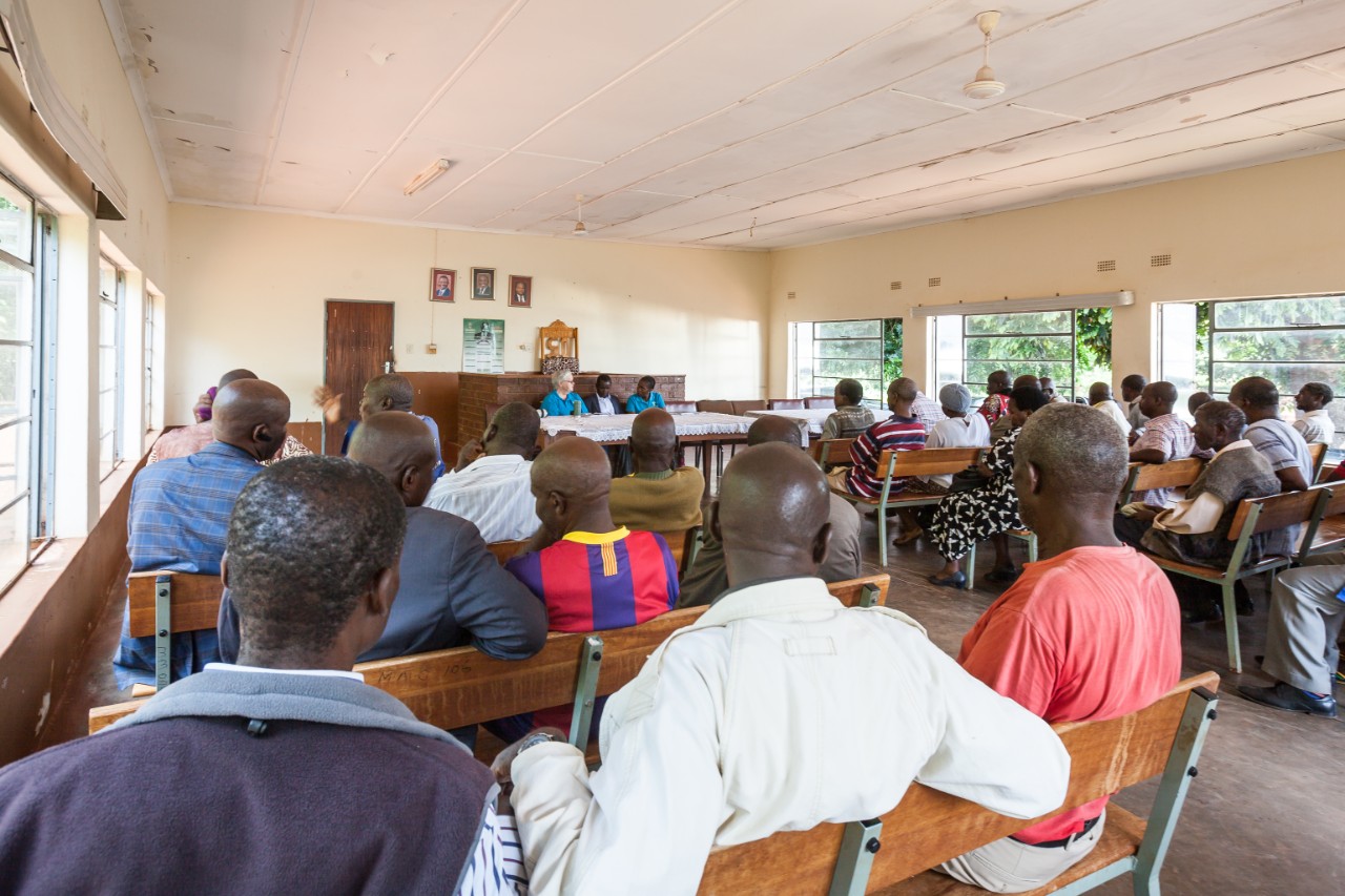 A professor and colleagues discussing the project with a community in South Africa