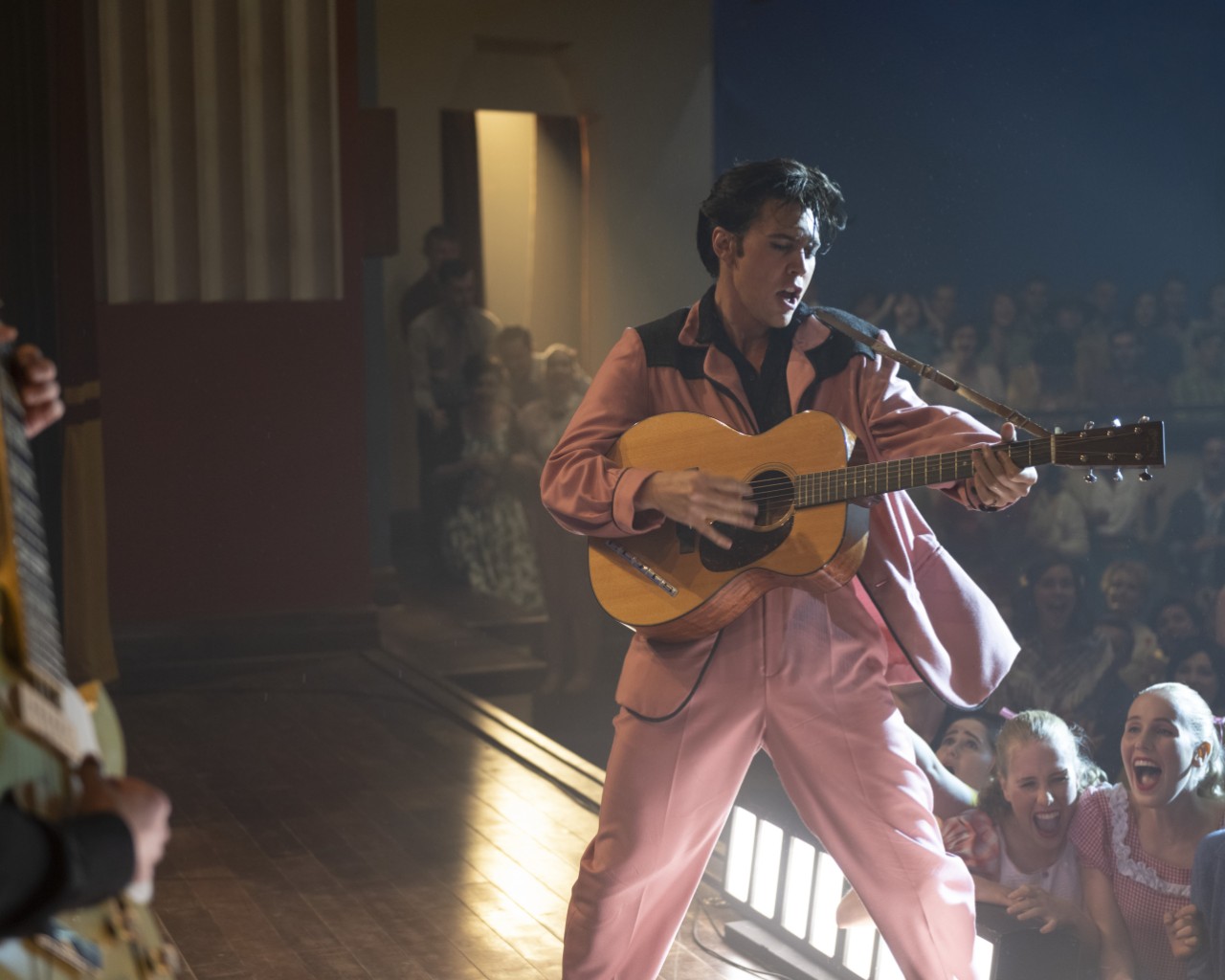 actor playing Elvis Presley dancing in a pink suit
