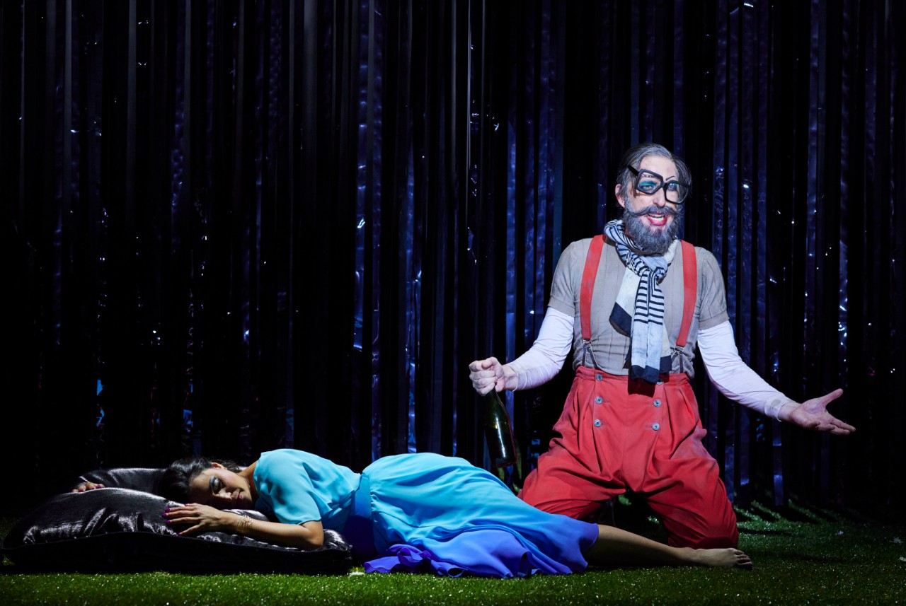 a female singer in a blue dress lies on the floor