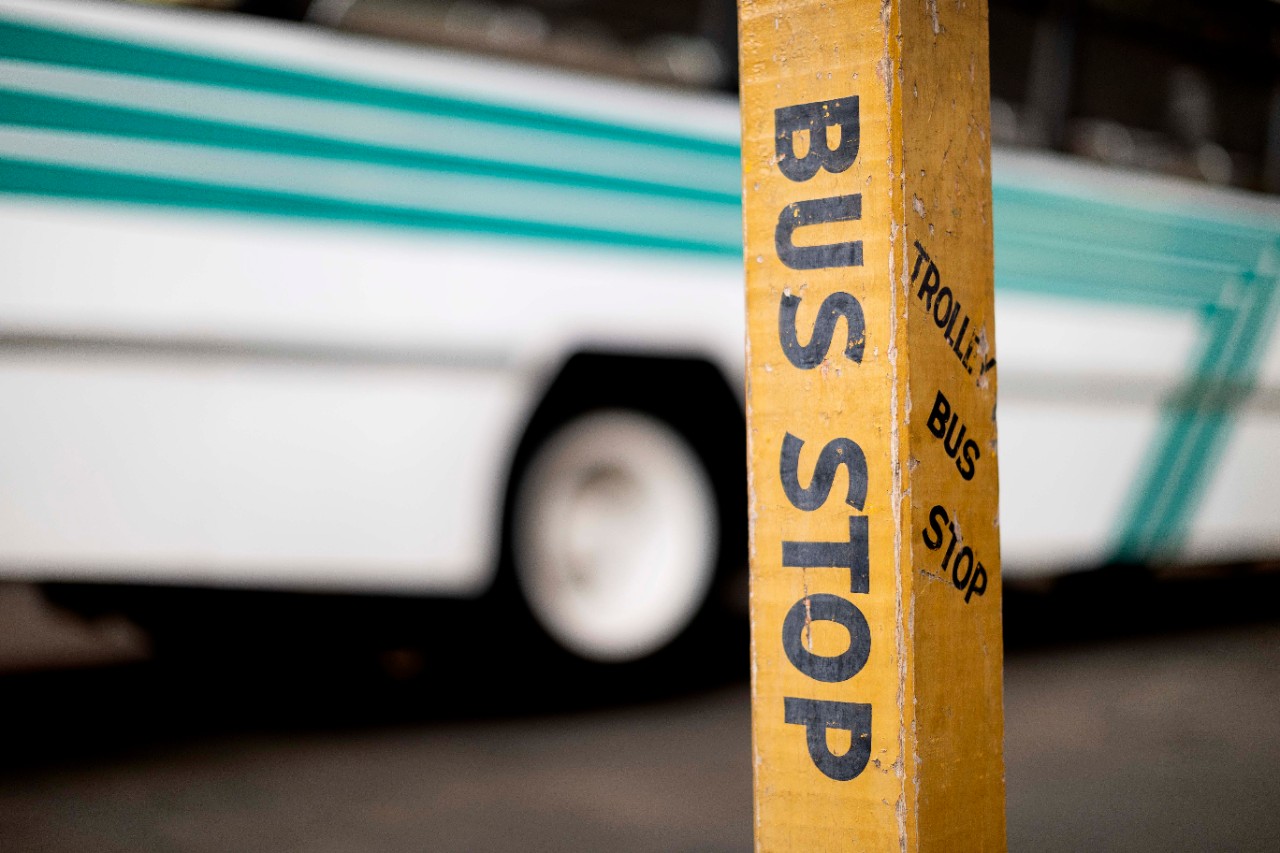 Bus next to bus stop sign
