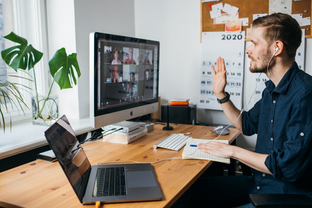 Man speaking on a video conference with work colleagues at home.
