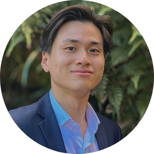 Matthew Shu in front of greenery 