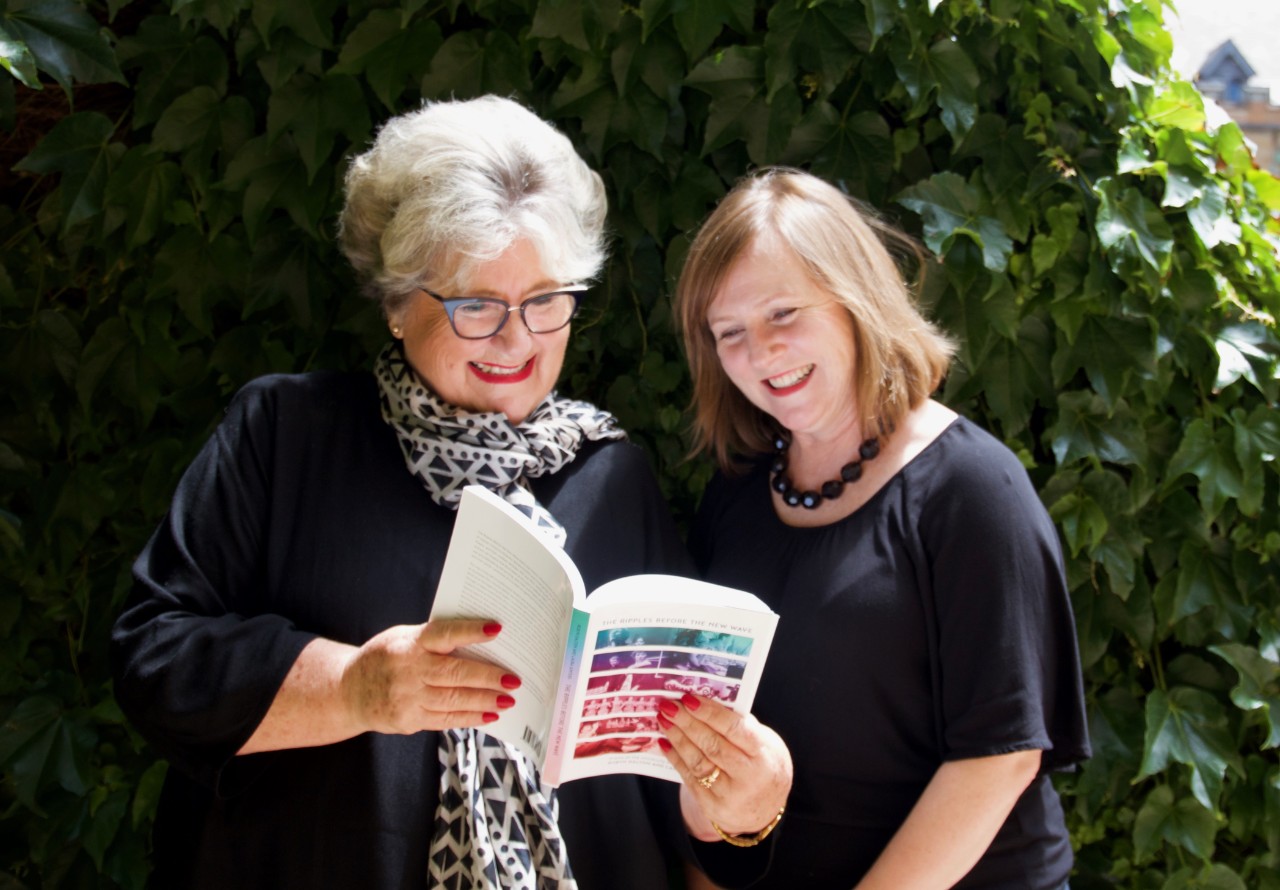 Two women reading a book