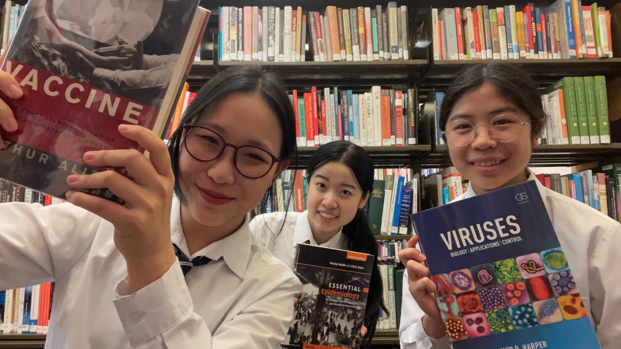 Aidi, Tara and Ellen holding up a book and smiling