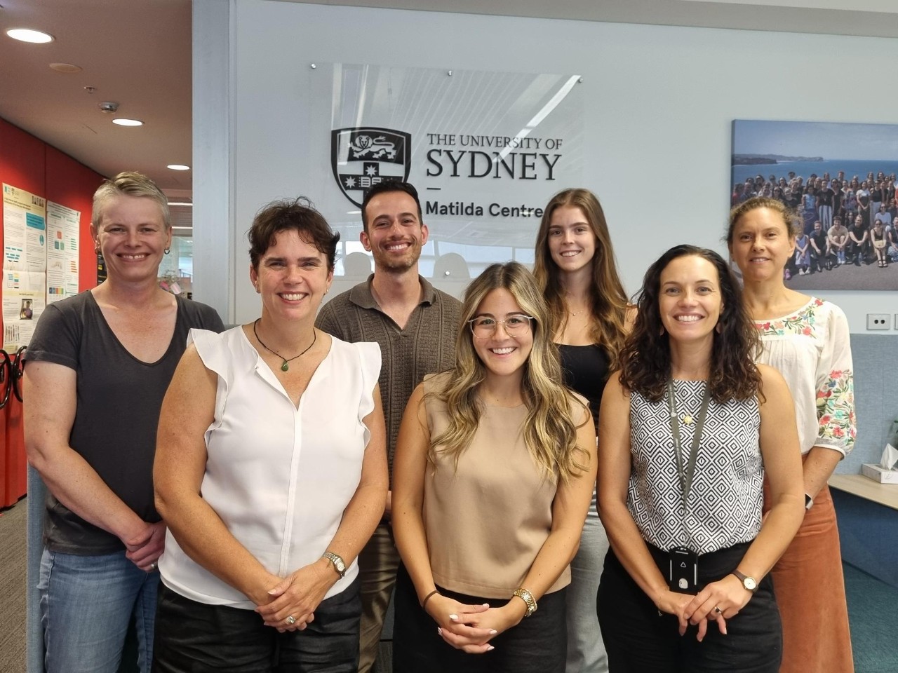 a large group of people standing in front of chairs and the Matilda Centre logo.
