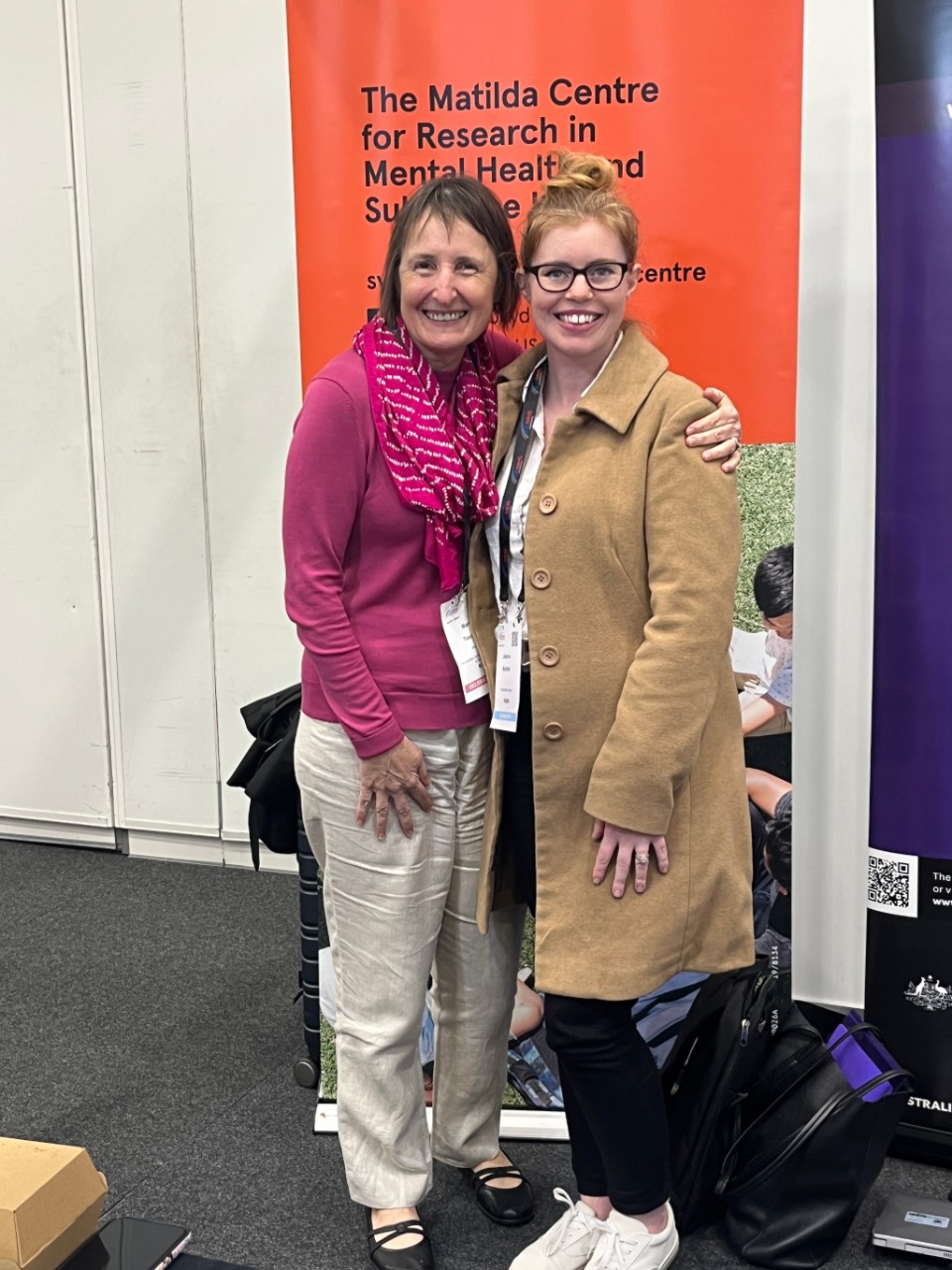 Professor Maree Teesson stands with Jasmin Bartlett in front of a Matilda Centre banner. 