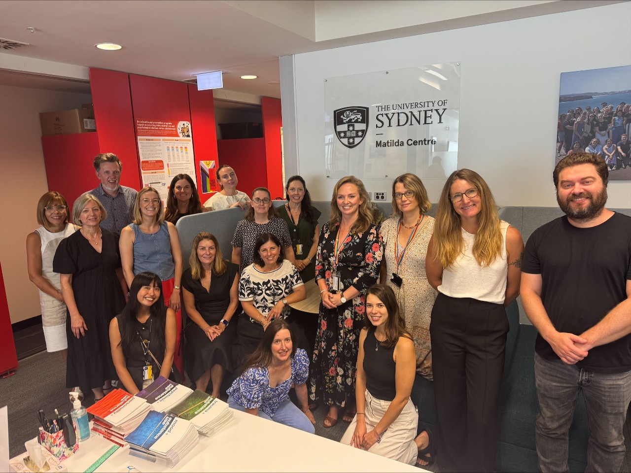 a large group of people standing in front of chairs and the Matilda Centre logo.