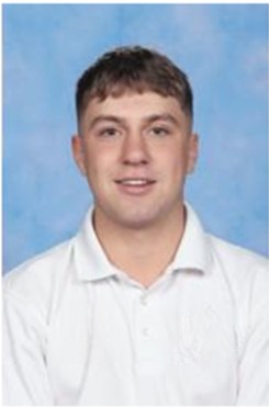 a man with short black hair and a white button up shirt with a blue background. 