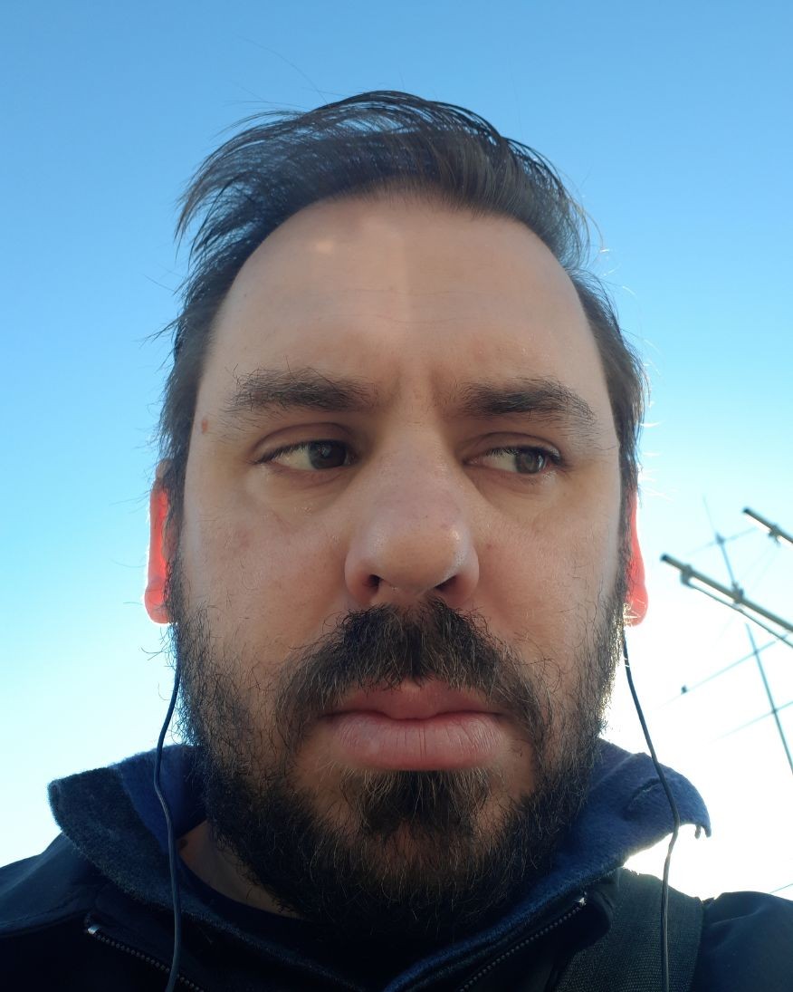 A close up image of Dr Matthew Chrulew with the blue sky in the background 