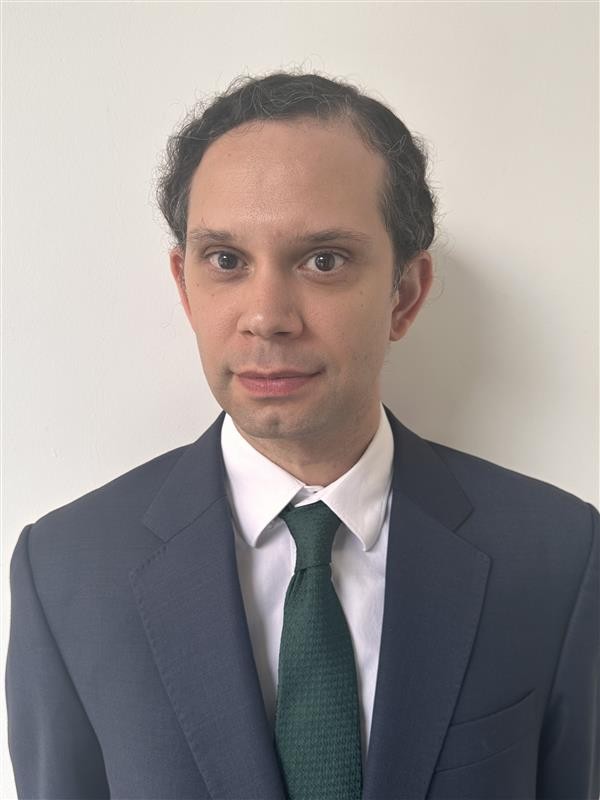 Head shot of Justin Hastings in a suit. 