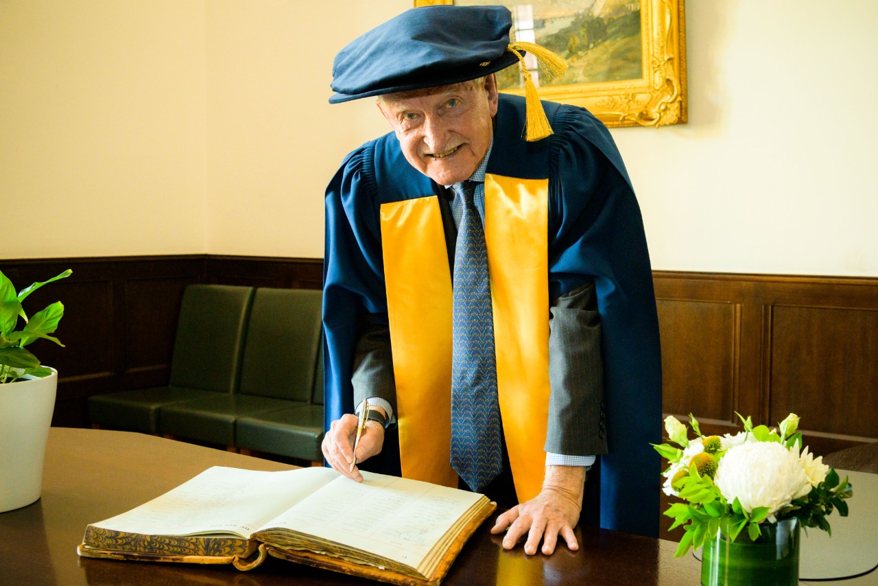 photo of Ross Steele signing a book