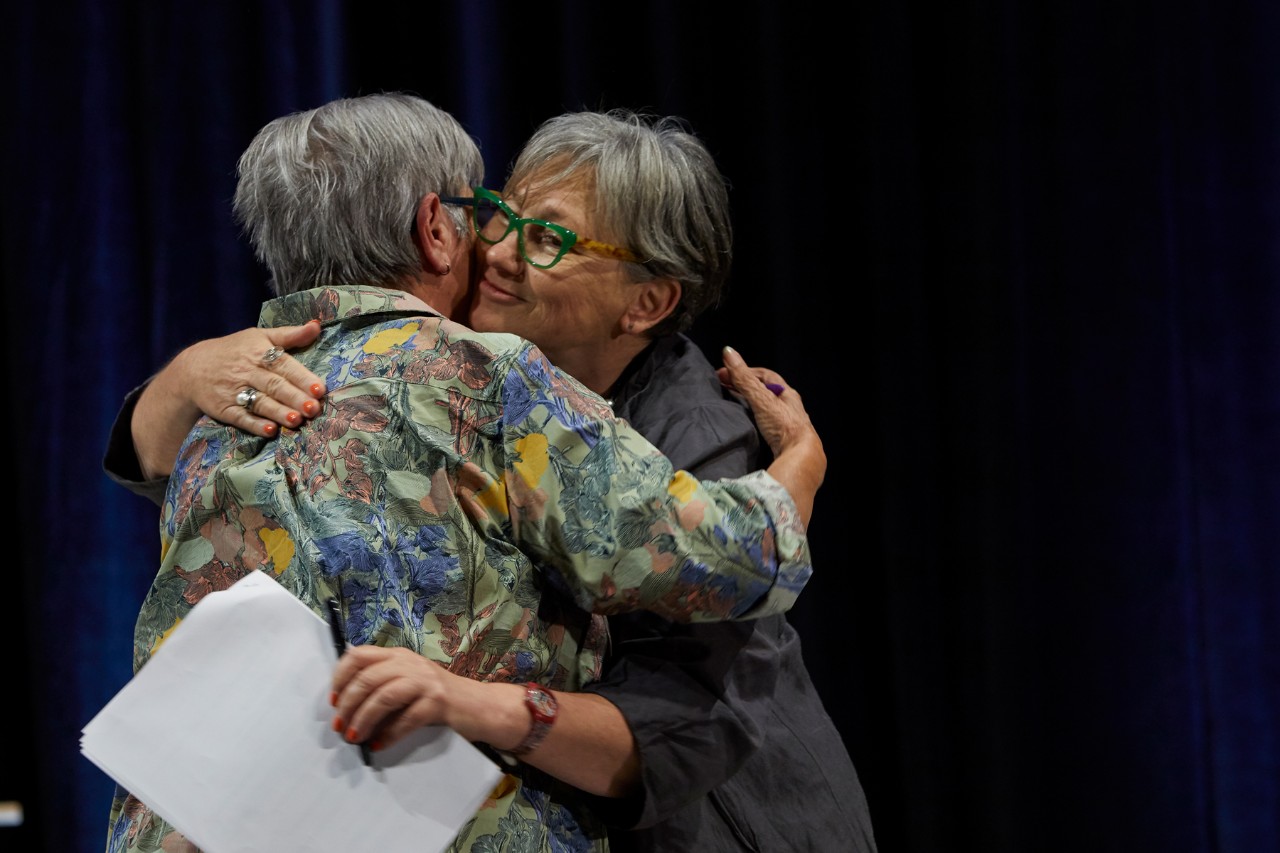 Pat Anderson and Juanita Sherwood warmly embrace.