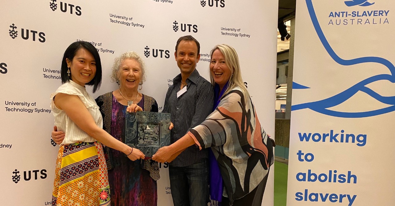 Four people holding award, celebrating their win
