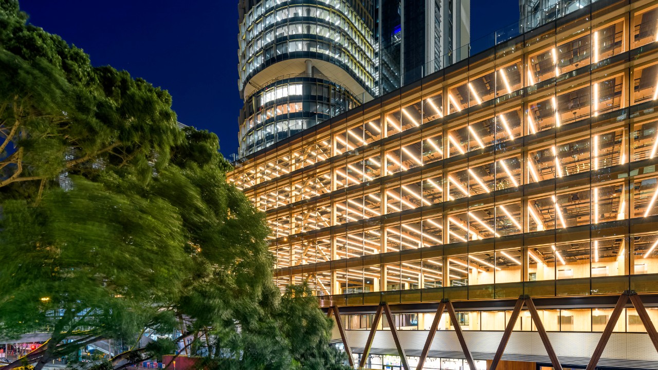 A dazzling night time shot of International House. It is empty since the tenants haven't moved in yet, but the lights are on so its five floors look open and bright. Looking behind it in a Sydney skyscraper.