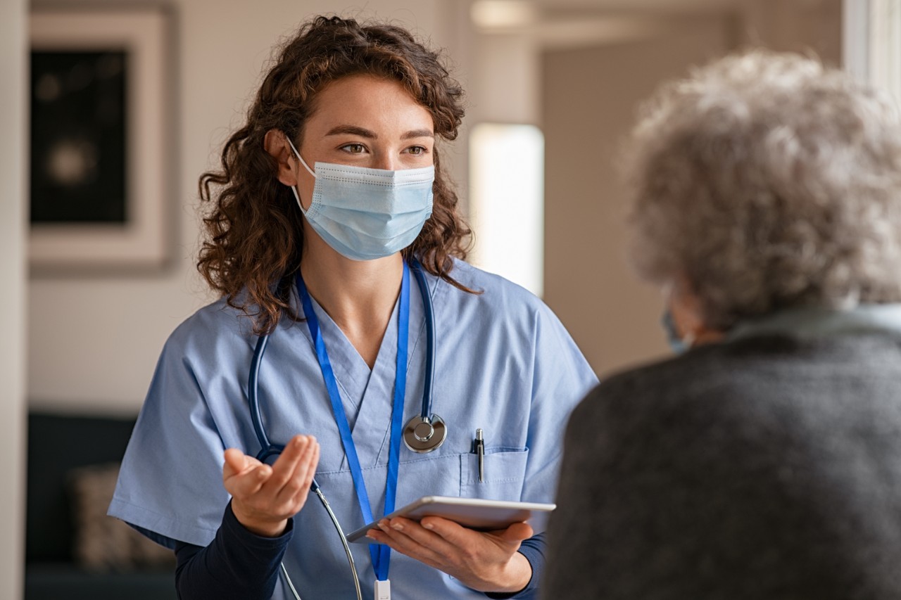 Doctor wearing mask speaks with patient 