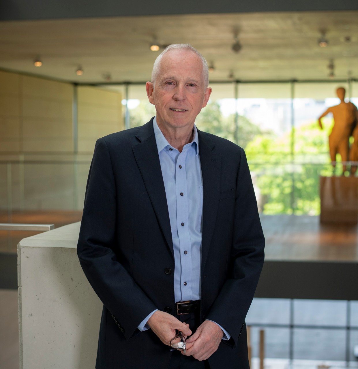 David Ellis at the Chau Chak Wing Museum with a statue, obscured, in the background