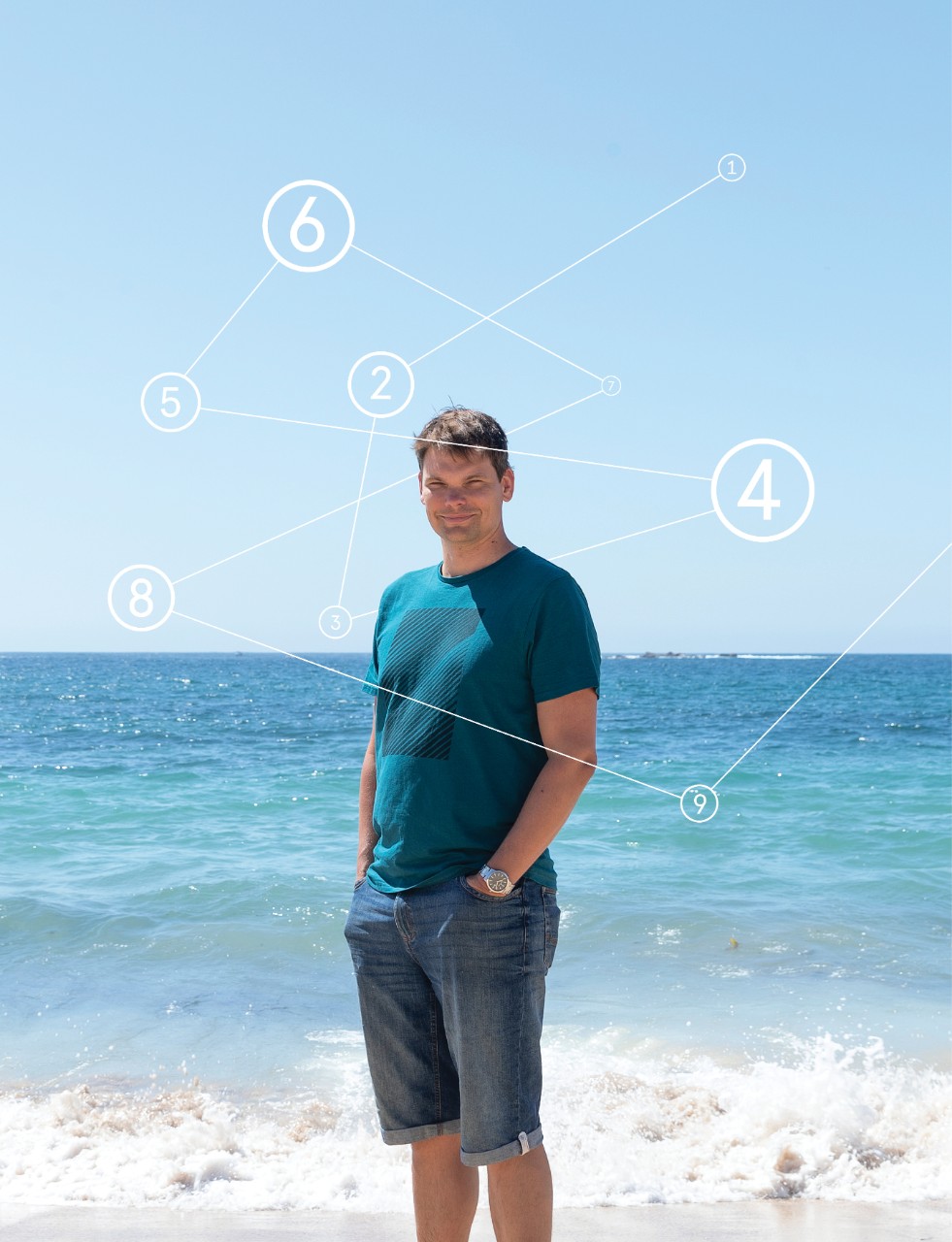 Mid shot of Arne Geschke, from knees up in front of waters edge at a beach