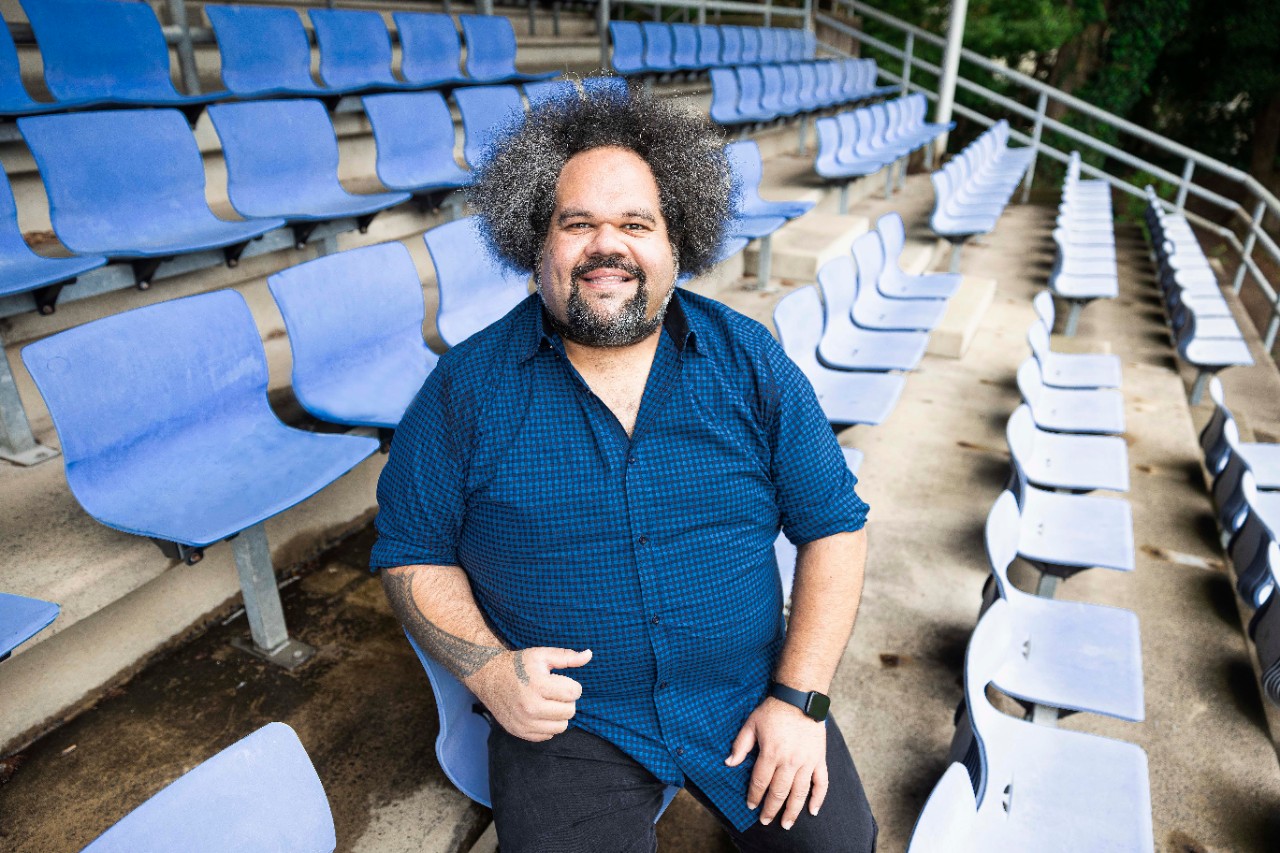 photo of Professor Jioji Ravulo sitting in football stadium seats
