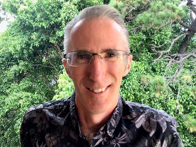 photo of a male academic with glasses smiling