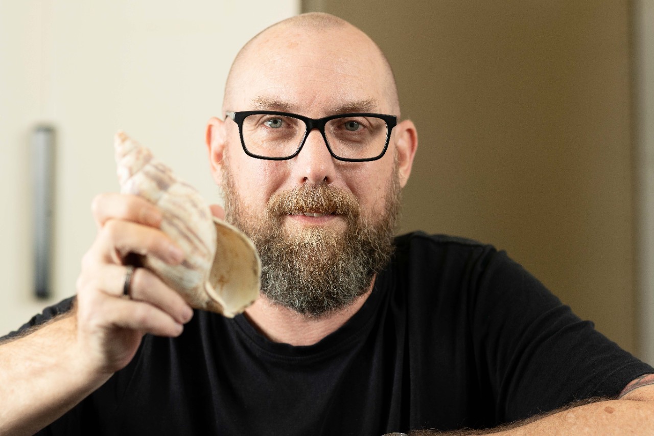 photo of Dr Patrick Faulkner holding a shell