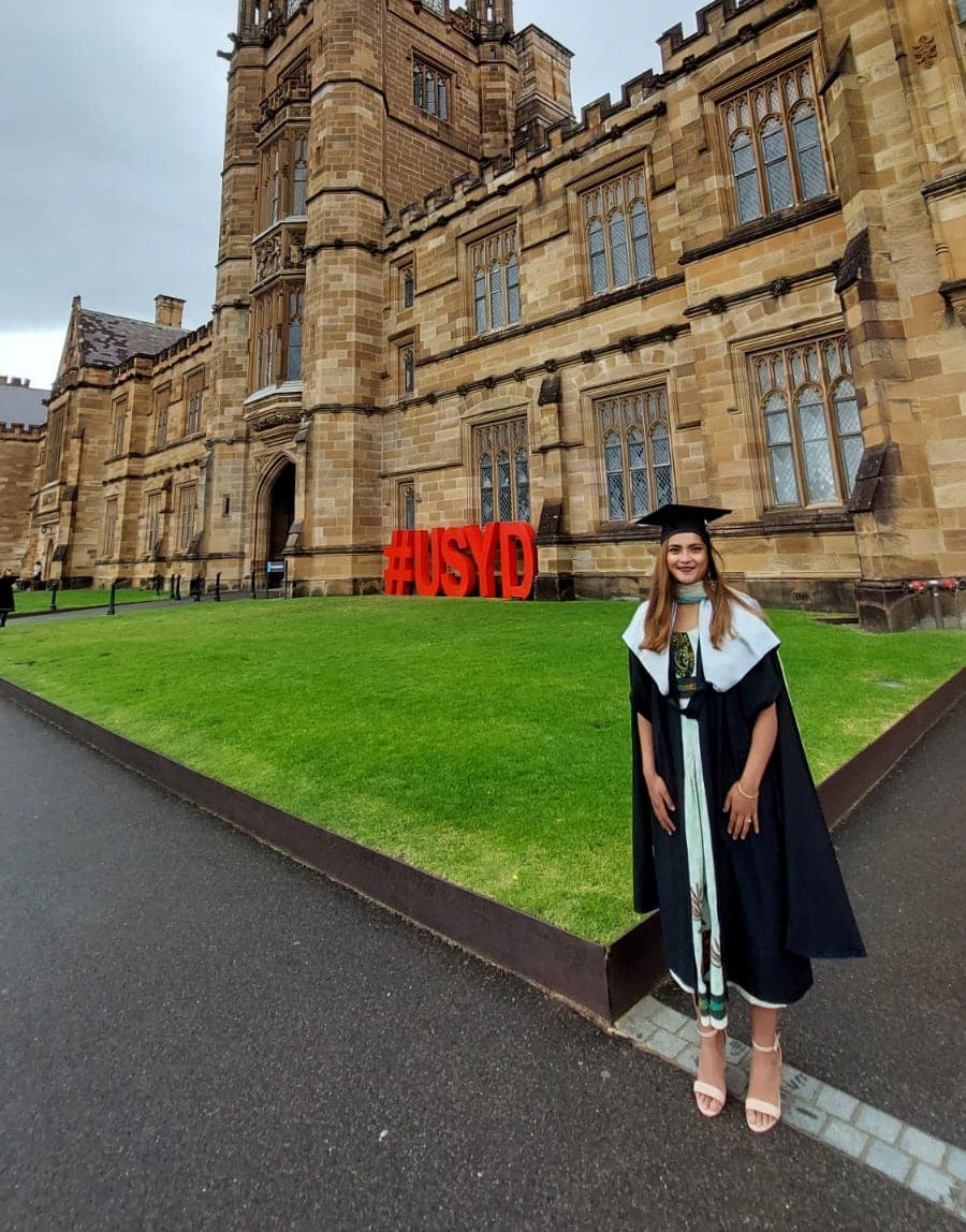 Noor Azizah in her graduation gown outside The Quadrangle building