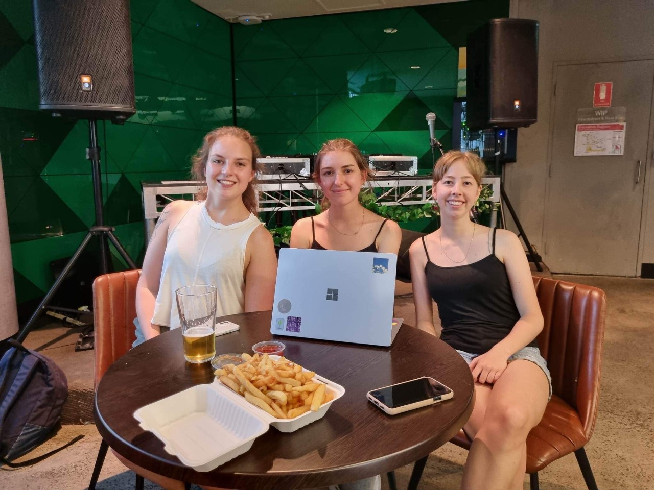 Photograph of Leilah, Irene and Ren from Waste Fighters Soc sitting at a table.