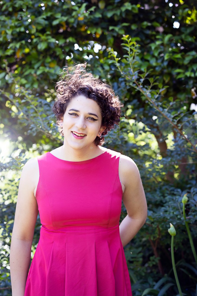 Amy McCarthy stands in front of a Jacaranda tree on the University of Sydney Camperdown campus.