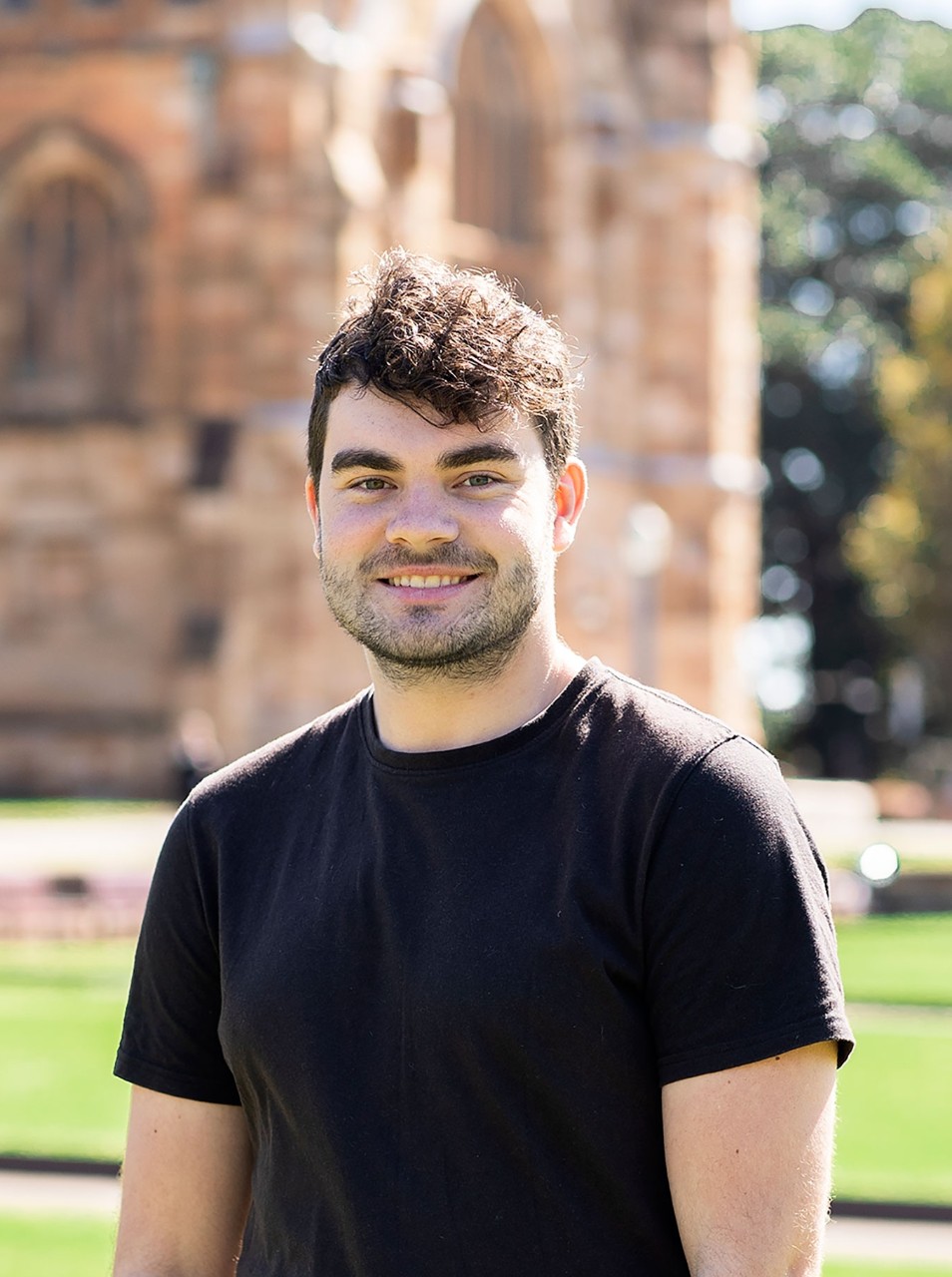 Thomas posing for a portrait shot in fron of Sydney University quadrangle