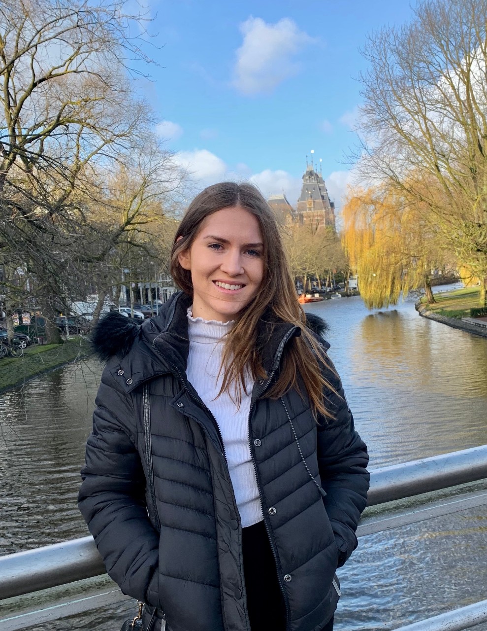 Caitlin smiling and posing in front of a lake