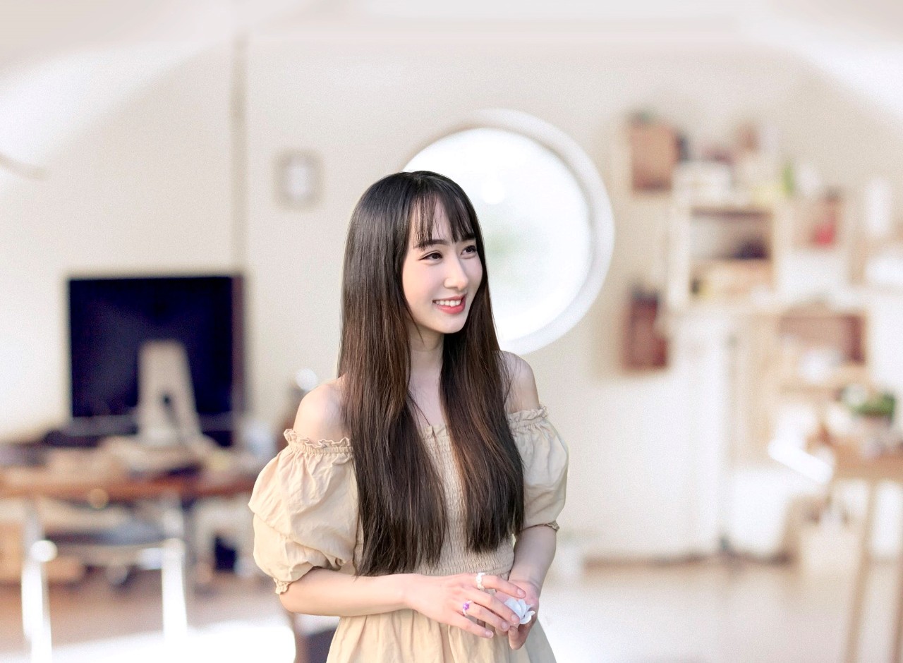 Kaitlyn Cho wearing a dress and standing in a studio