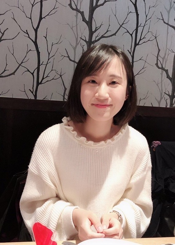 A woman with dark hair in a white jumper