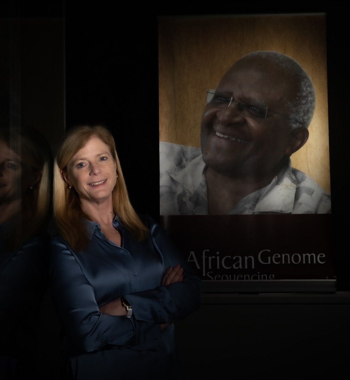 Vanessa Hayes with a picture of a man on the wall in the back