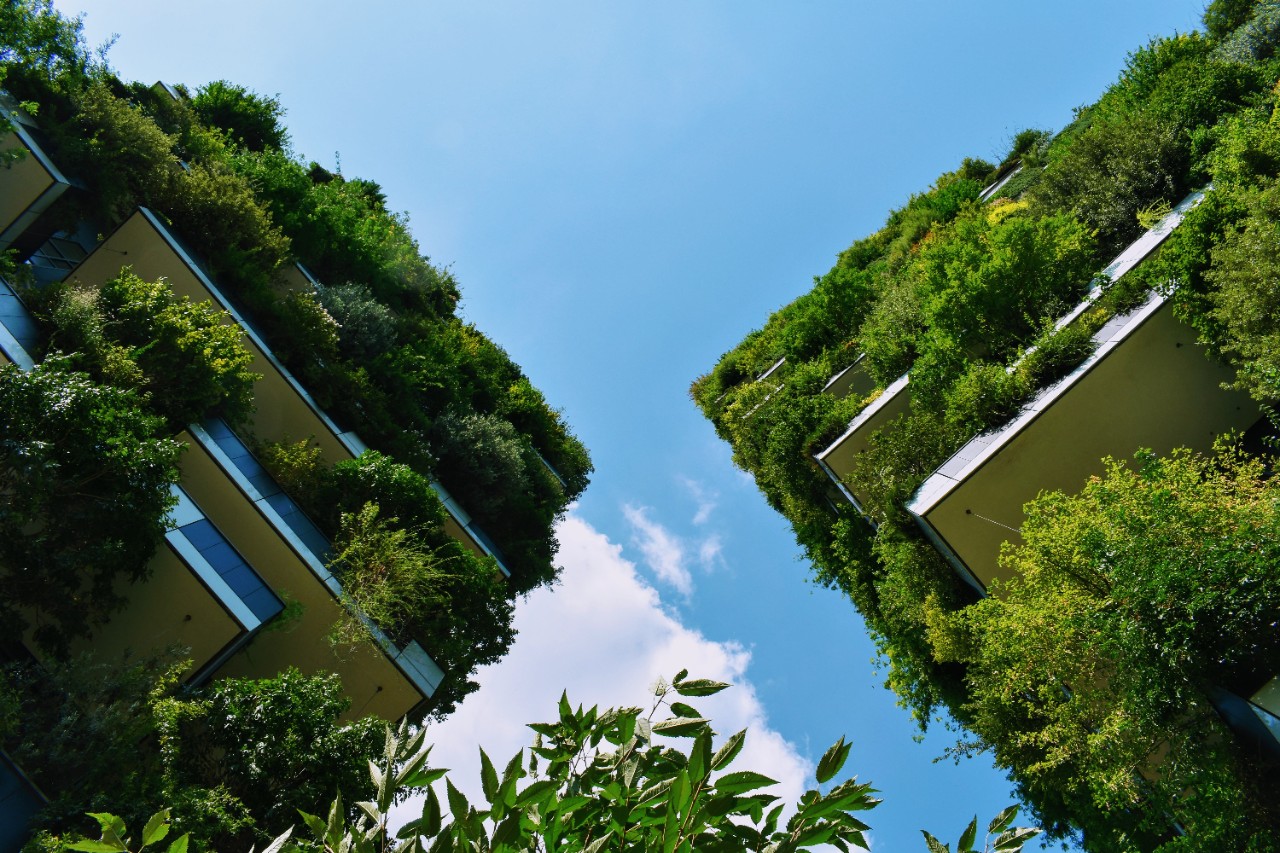 A photo of a multi-story eco building looking up from the street level