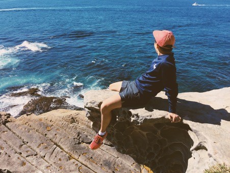 young man sitting by the ocean