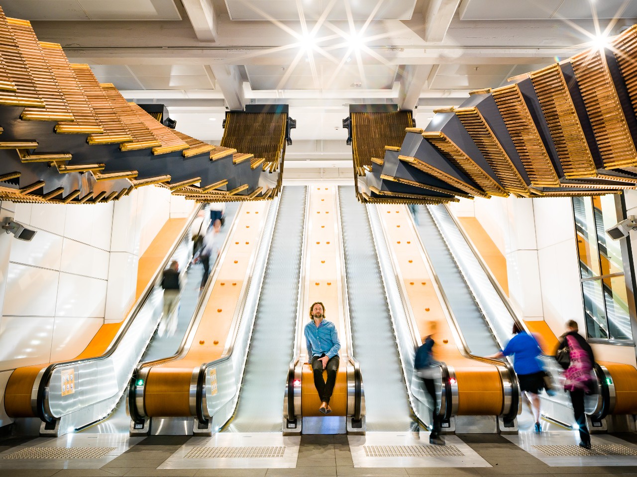 Artist and sculptor Chris Fox (centre) with his new installation Interloop at Wynyard Station. Photo: Josh Raymond