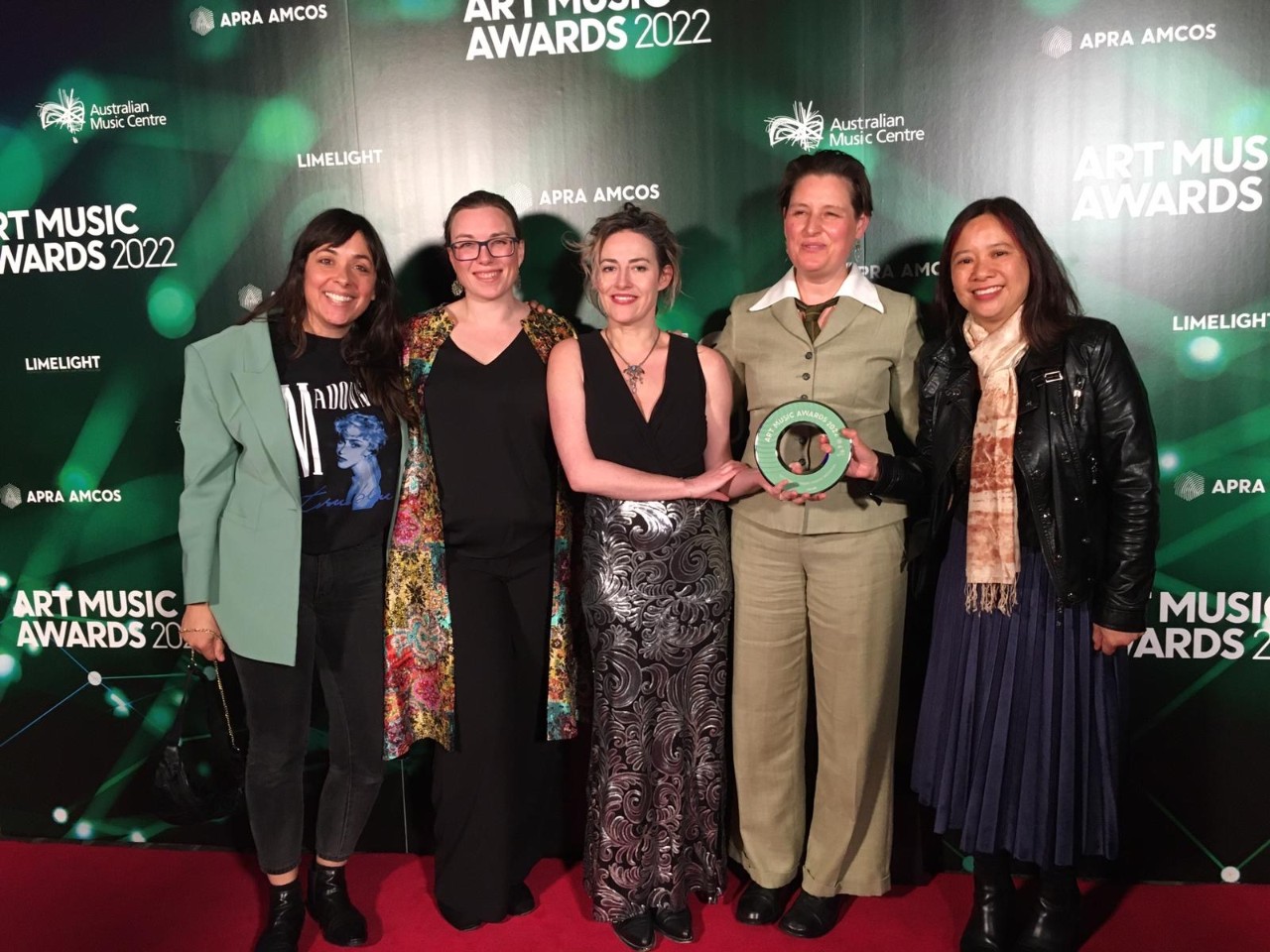 photo of five women receiving a trophy and smiling