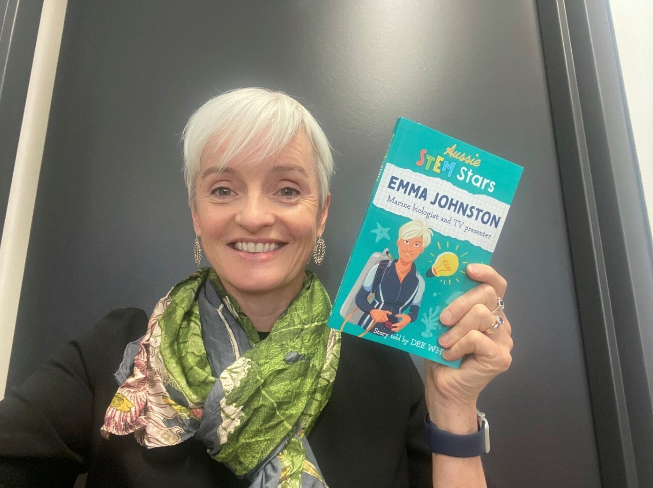 Woman holding book with graphic of her on the cover